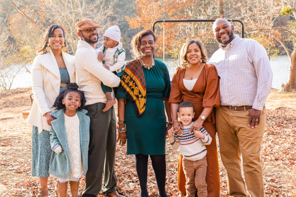 Multi generation photo session with grand parents parents and toddlers standing in front of a pond in Atlanta GA