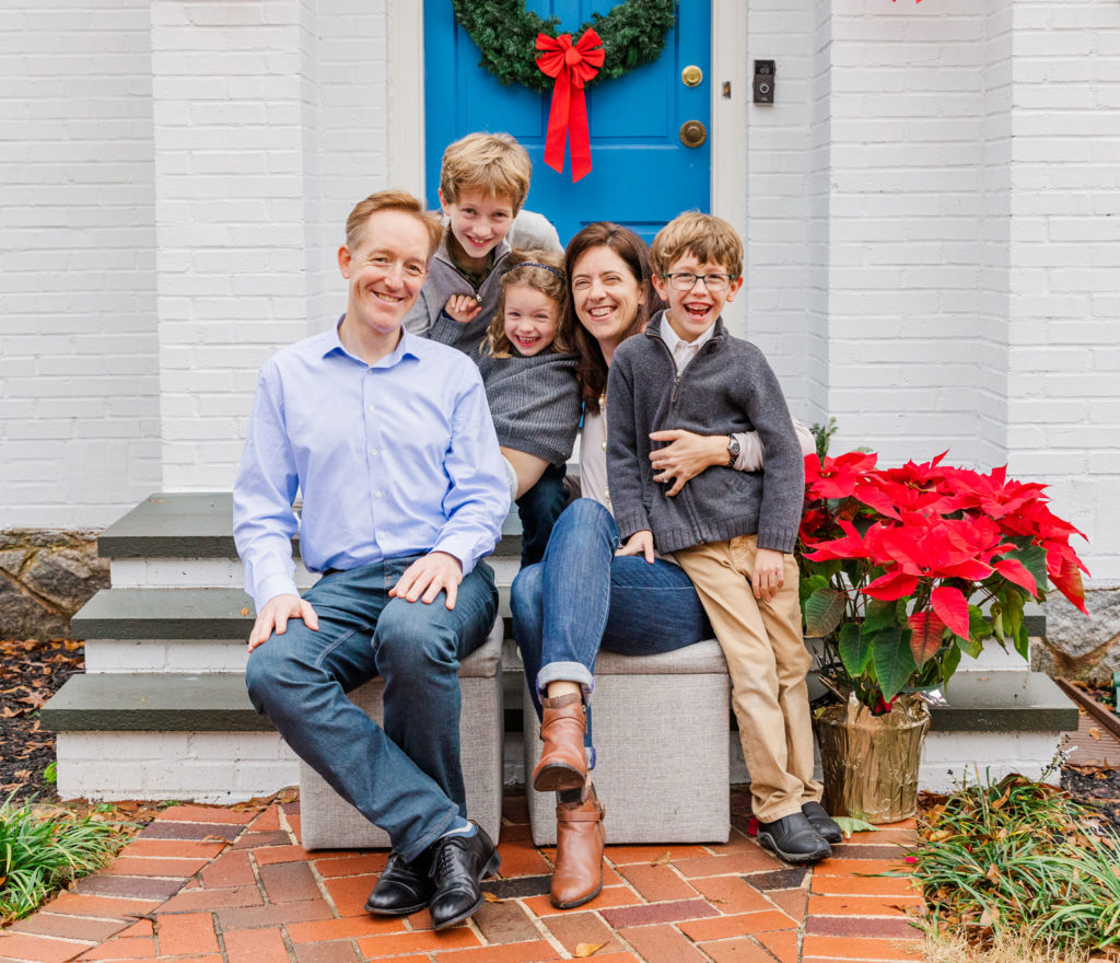 fun family picture while having fun sitting in front of blue door in Atlanta