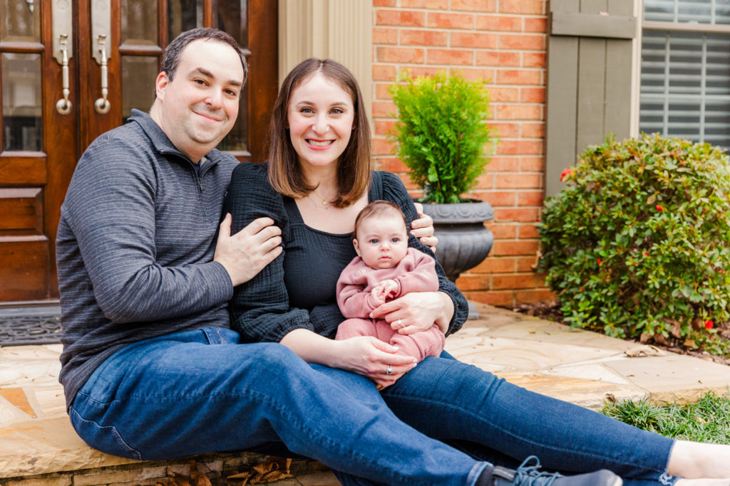 new parents and baby girl sitting on front of their house in Dunwoody GA by Laure photography