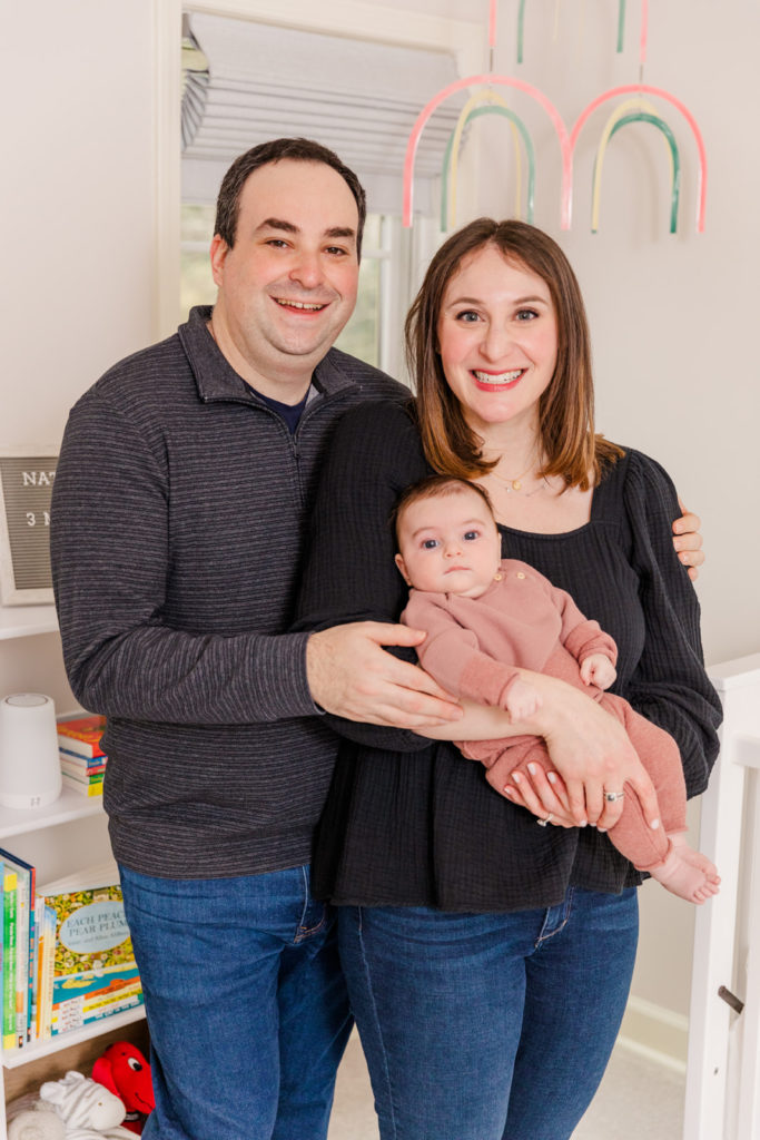 parents holding 3 month old baby standing in the nursery during milestone photo session in Atlanta GA