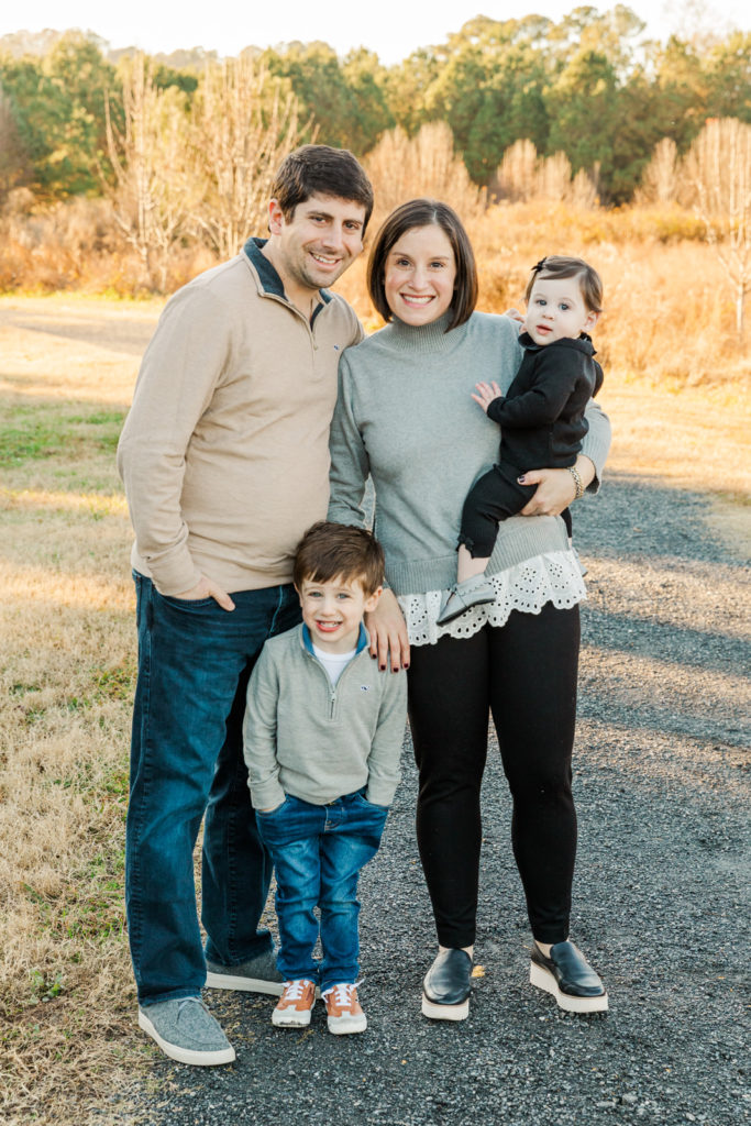 family with toddler and baby standing a a park path in Alpharetta GA during fall family photo session