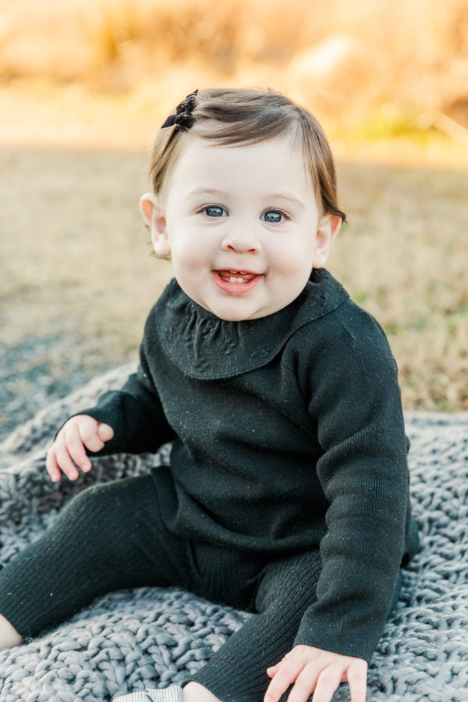 baby girl sitting on a blanket in Atlanta GA during family photo session with Laure Photography