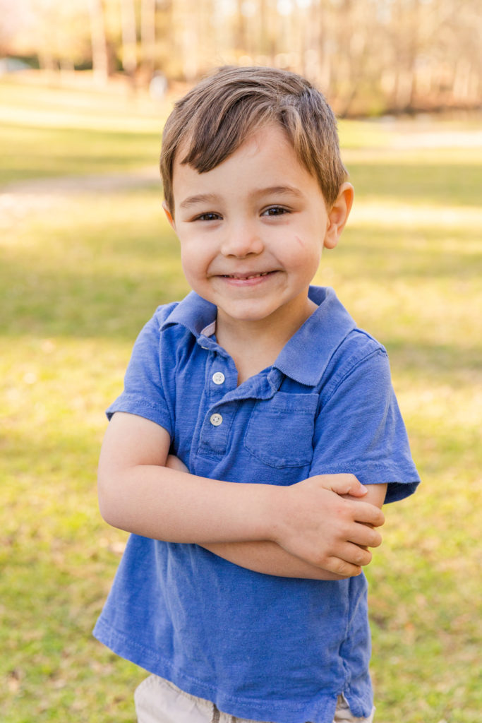 toddler boys in blue polo standing arms crossed in a park with Laure Photography Atlanta