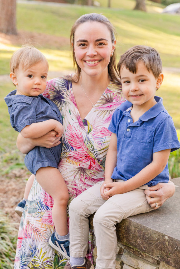 mommy and her two sons on un the mars and one sitting on a bridge mom wearing a flower dress and boys wearing blue polos with Laure Photography Atlanta