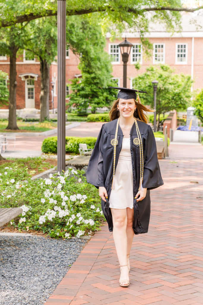 Georgia Tech college graduation graduate in cap & gown walking on campus by Atlanta Photographer Laure Photography