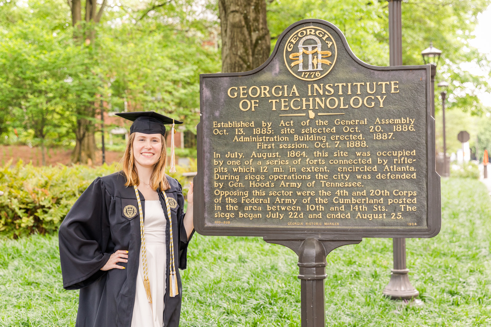 College Georgia Tech graduate in cap and gown in front of the school Historic monument by Atlanta Photographer Laure Photography