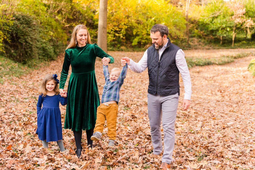 family walking hands in hands making a toddler swing Atlanta GA park Laure photography lifestyle family photo session