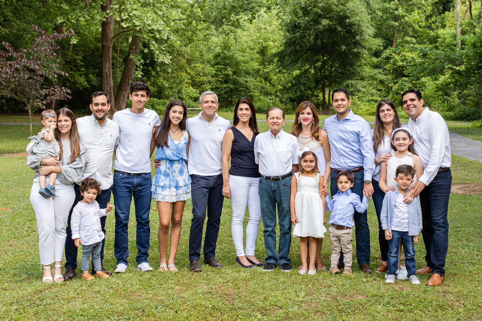 Extended family of 17 people and 3 generations with coordinated blue and white outfits in Atlanta park Sandy Spring Laure photography