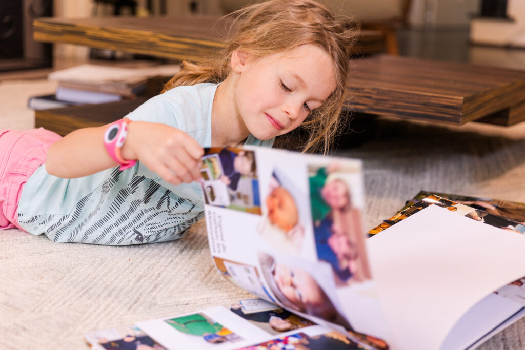 Child looking at family photo album by brand and family photographer Laure Photography