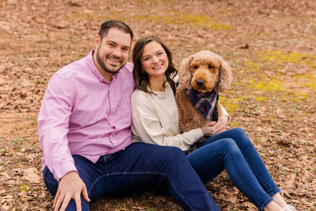 Couple sitting on the ground in a park with their dog by Atlanta family photographer Laure Photography