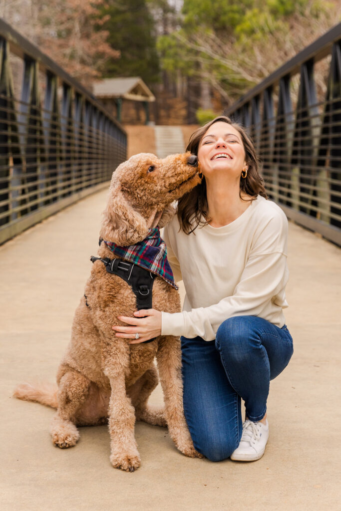 candid picture of a woman having fun with her dog on a bridge during photo session by Atlanta family photographer Laure Photography