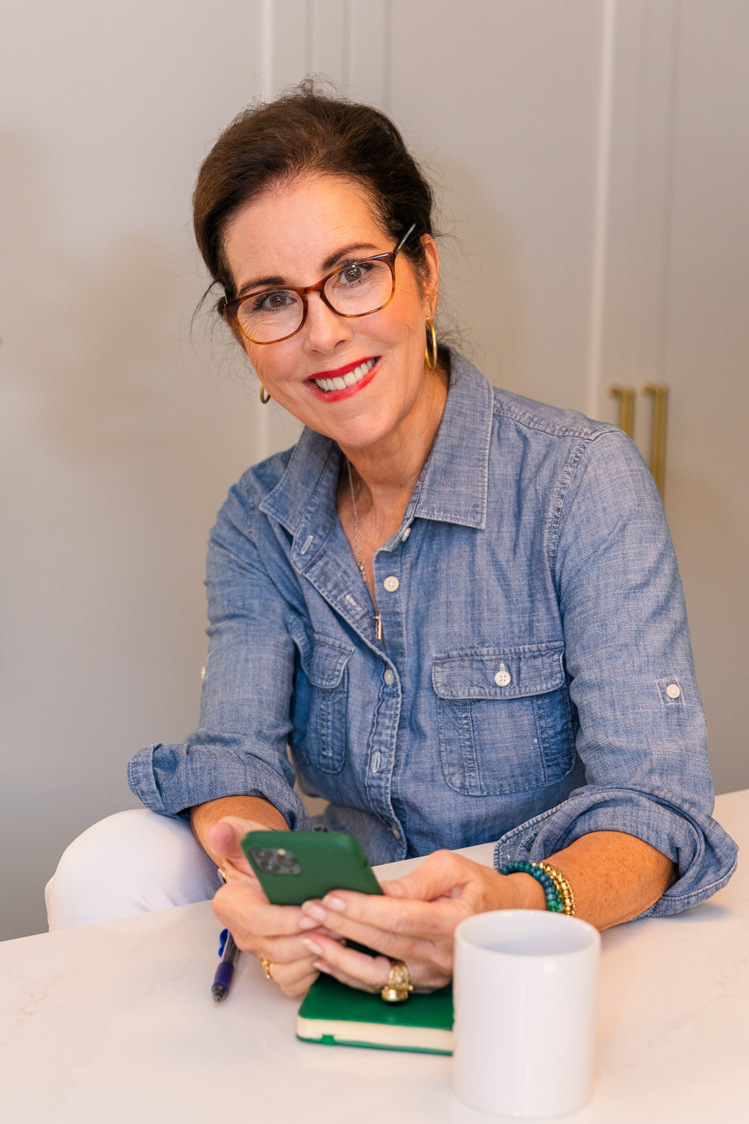 woman texting and looking at the camera wearing white jeans and blue denim jacket during brand photo shoot Atlanta with Laure Photography