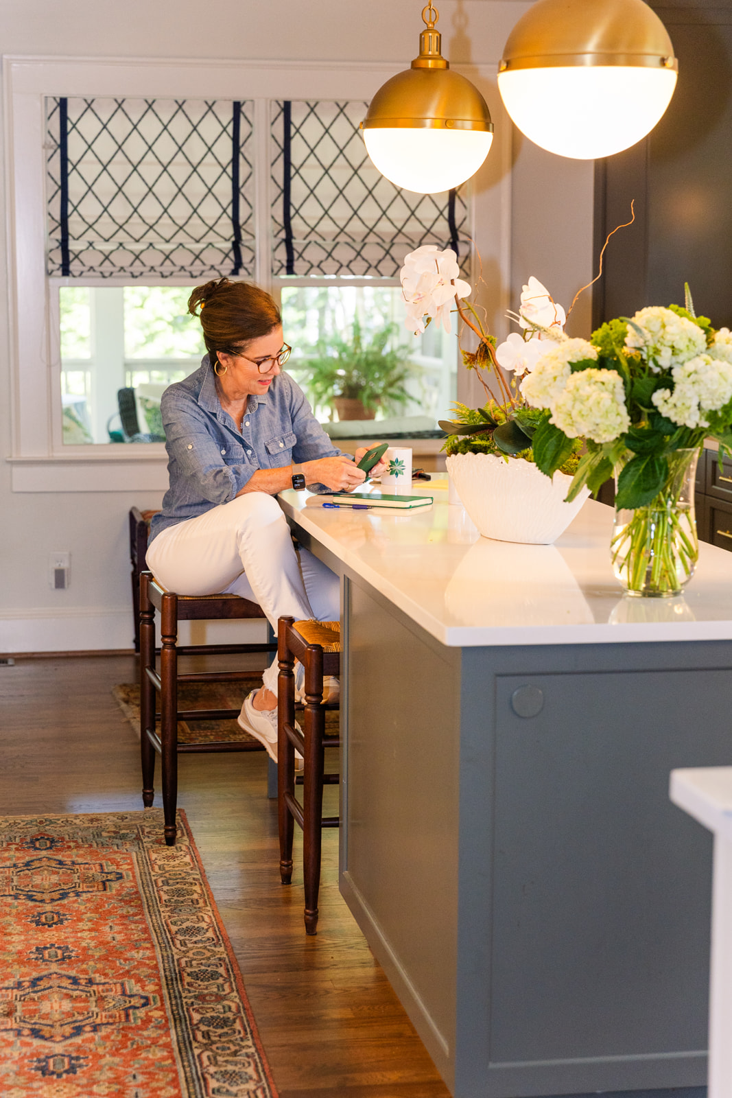 woman working in her kitchen wearing white jeans and blue shirt brand photo shoot Atlanta with Laure Photography