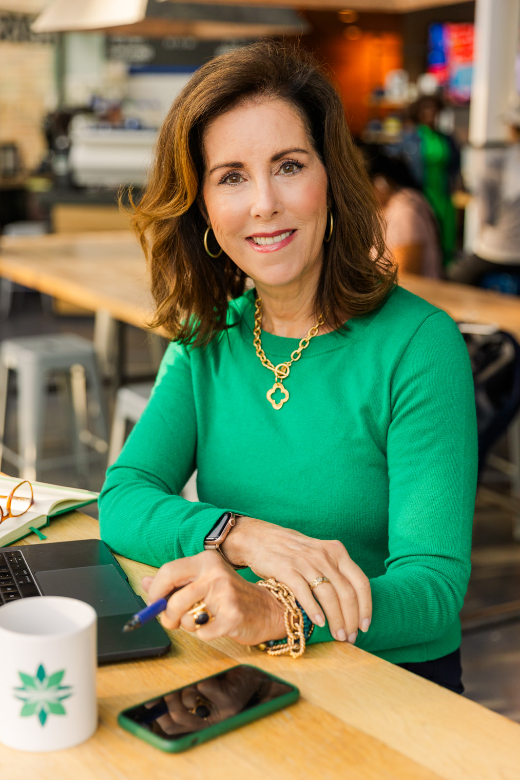 woman worming in a coffee shop wearing a green top during brand photo shoot Atlanta with Laure Photography