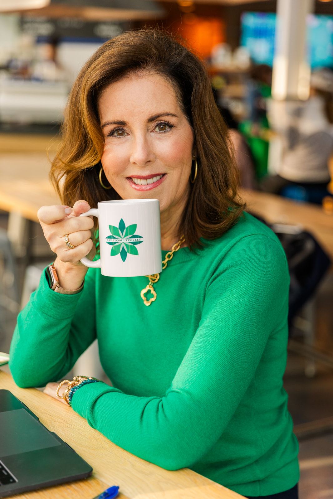 woman taking a break from working and drinking coffee from branded mug in a coffee shop brand photo shoot during Atlanta with Laure Photography