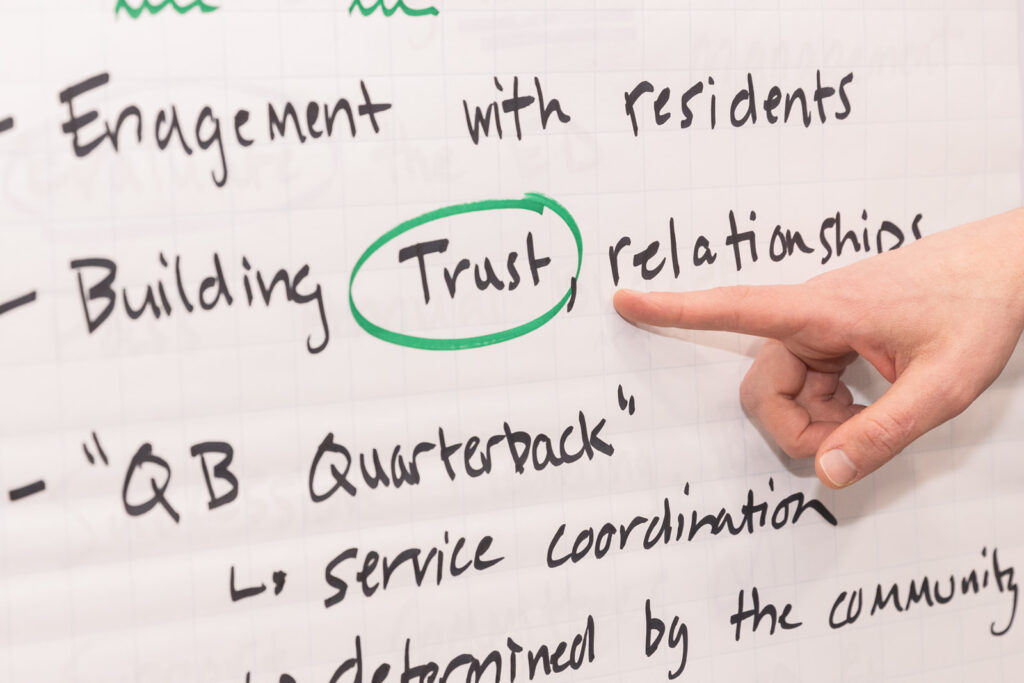 Close-up of hand pointing to the word "trust" on a paper board during brand photoshoot in Atlanta
