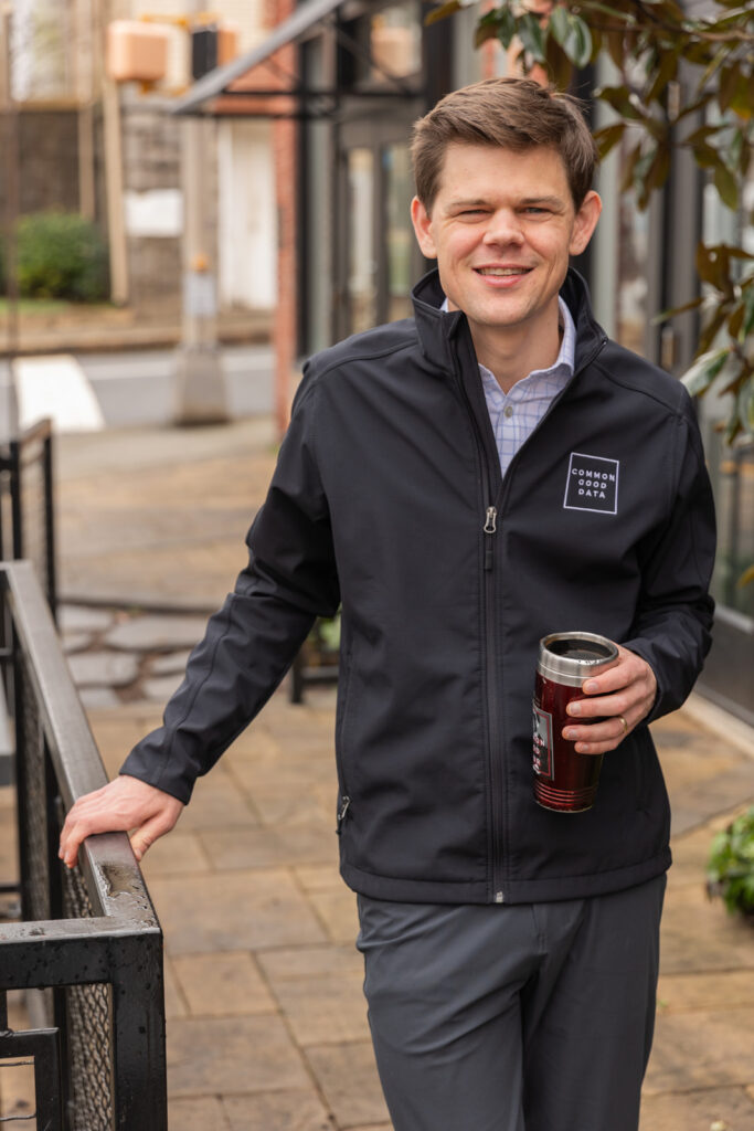 Consultant holding coffee tumbler standing outside coffee shop during personal brand photoshoot in Atlanta