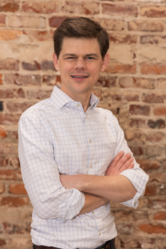 Consultant headshot standing arms crossed in front of brick wall in Atlanta, captured by Laure Photography
