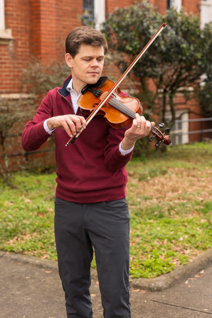 Business casual violin performance in front of a church during Atlanta brand photoshoot