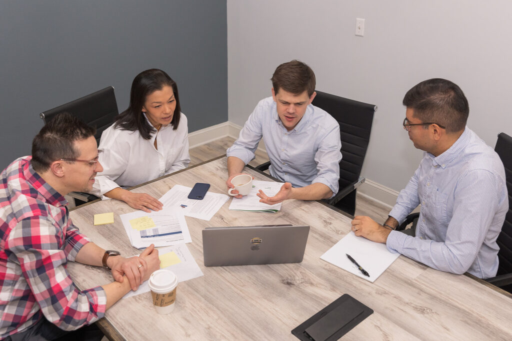 Professionals discussing documents and computer screen during meeting in Atlanta