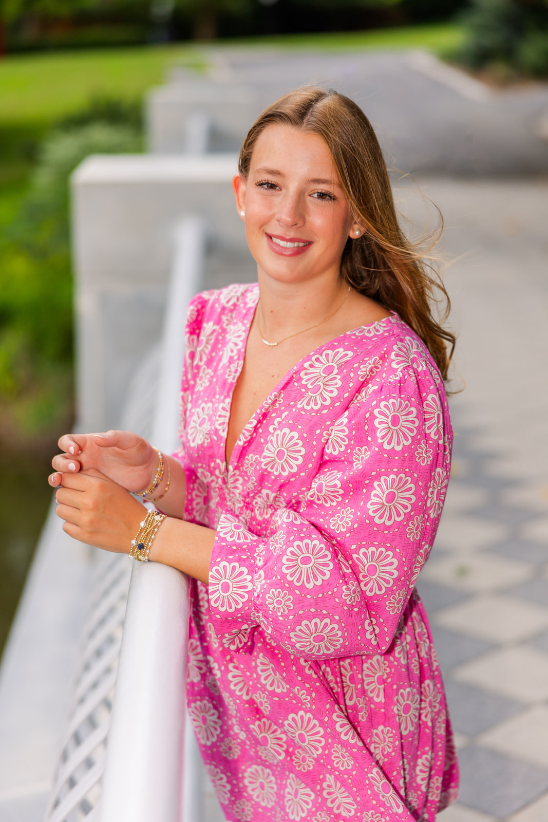 young adult leaning agains a bridge side during senior photo session in GA Atlanta park