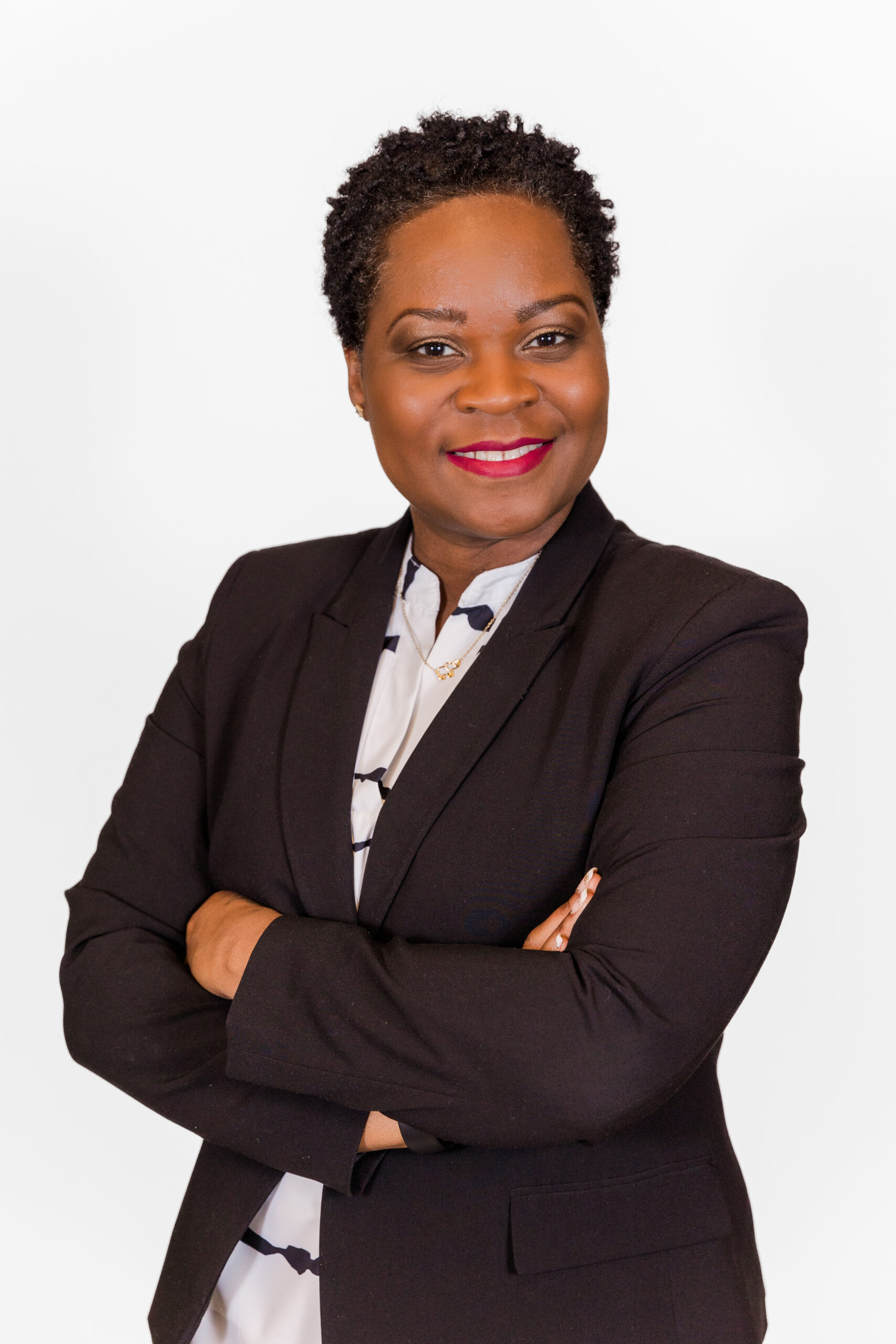 Julie-Ann Reid headshot session wearing a black jacket arms crossed standing in front of portable studio in Atlanta midtown office