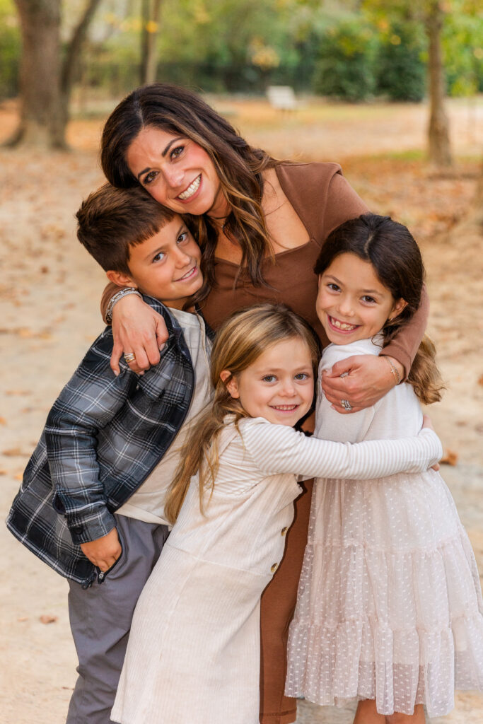 young kids and toddlers hugging mum during photo session in Atlanta Sandy Spring park by Laure Photography