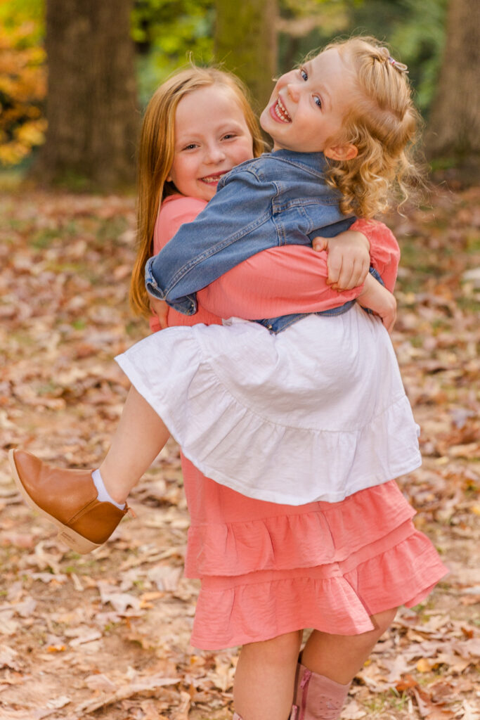young kids, toddler girl siblings holding each other and laughing in Atlanta outdoor park