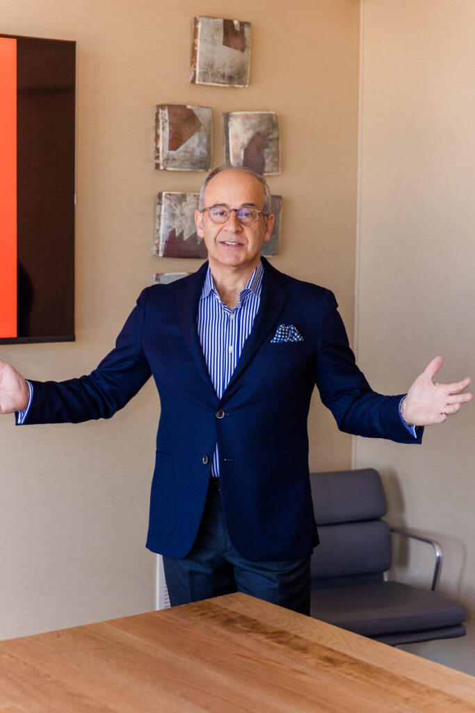 Ahmet Bozer making hand gestures while talking and looking at the camera during a conference room presentation in Atlanta Buckhead
