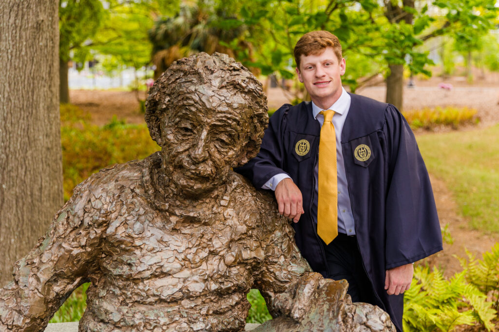 Jason standing proudly next to the Einstein statue at Georgia Tech