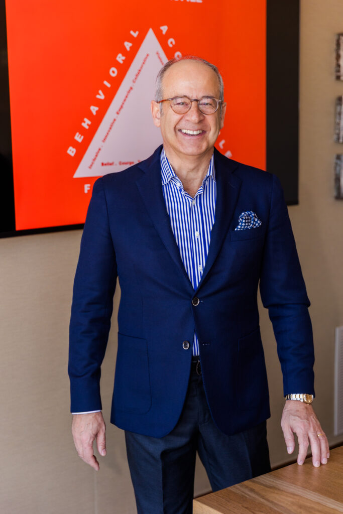 Ahmet Bozer standing in front of a conference room screen, laughing at the camera during his personal brand session in Atlanta’s Buckhead
