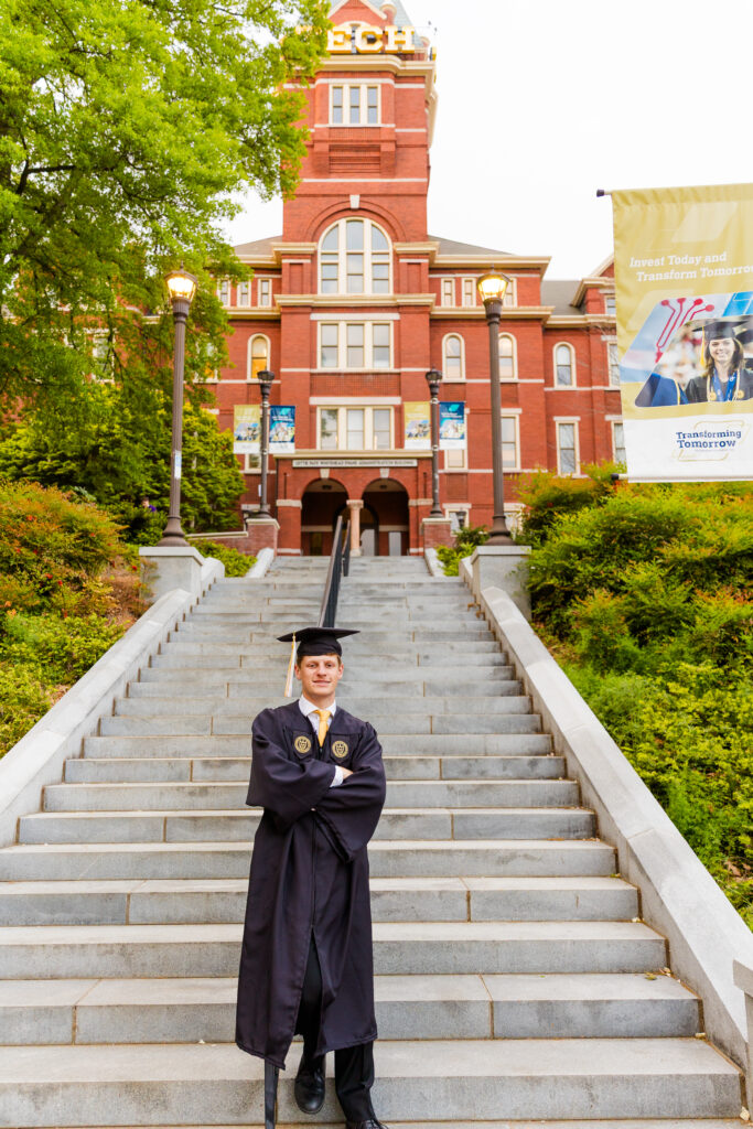Jason standing confidently at the base of the Georgia Tech campus Tower stairs with arms crossed during portraits session
