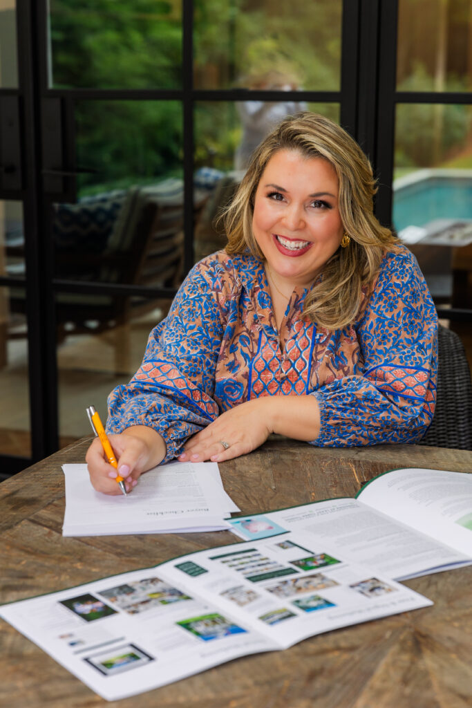 Woman writing in a notebook at her desk during a personal brand photo session in Atlanta with Laure Photography