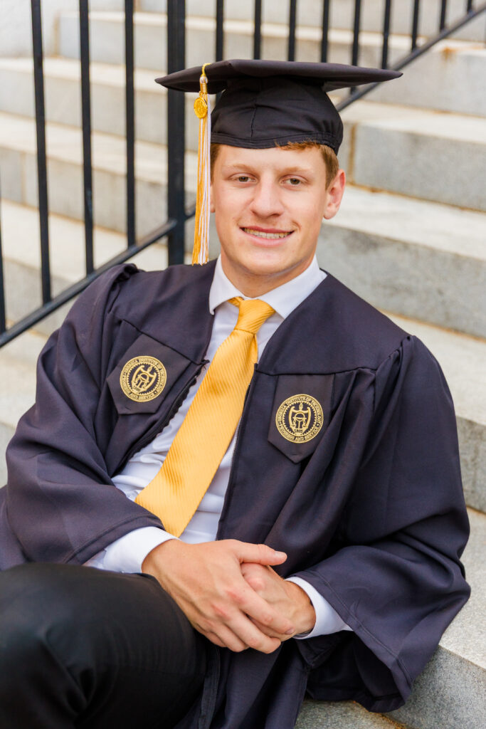 Jason senior student sitting on the iconic Georgia Tech stairs in front of the tower, elbow resting on the upper step.