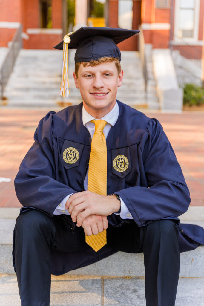 Jason sitting on the stairs, elbows on knees, hands together, looking at camera.