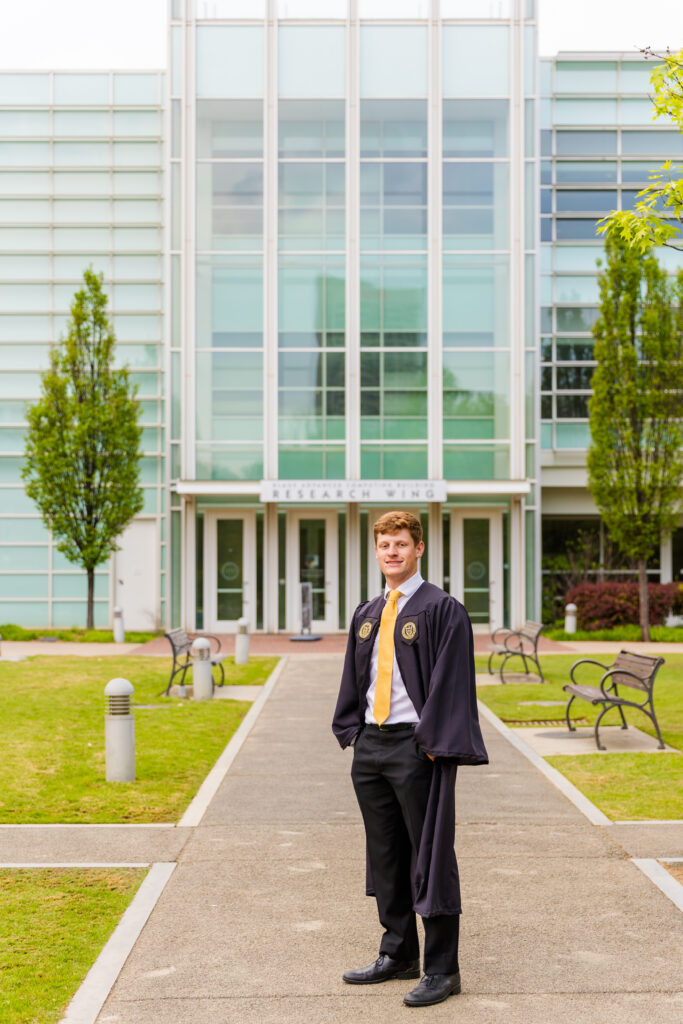 Jason standing proudly in front of the campus building where he spent most of his time.
