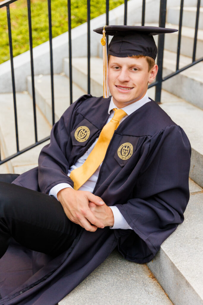 Close-up shot of Jason sitting on the Georgia Tech stairs with the tower in the background.