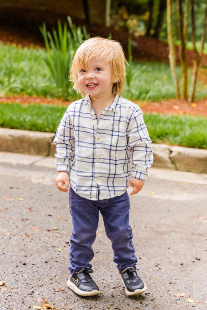 Toddler boy walking down the street with curiosity during a family session.