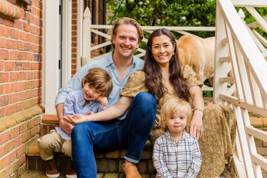Family seated on porch steps in relaxed, layered formation.
