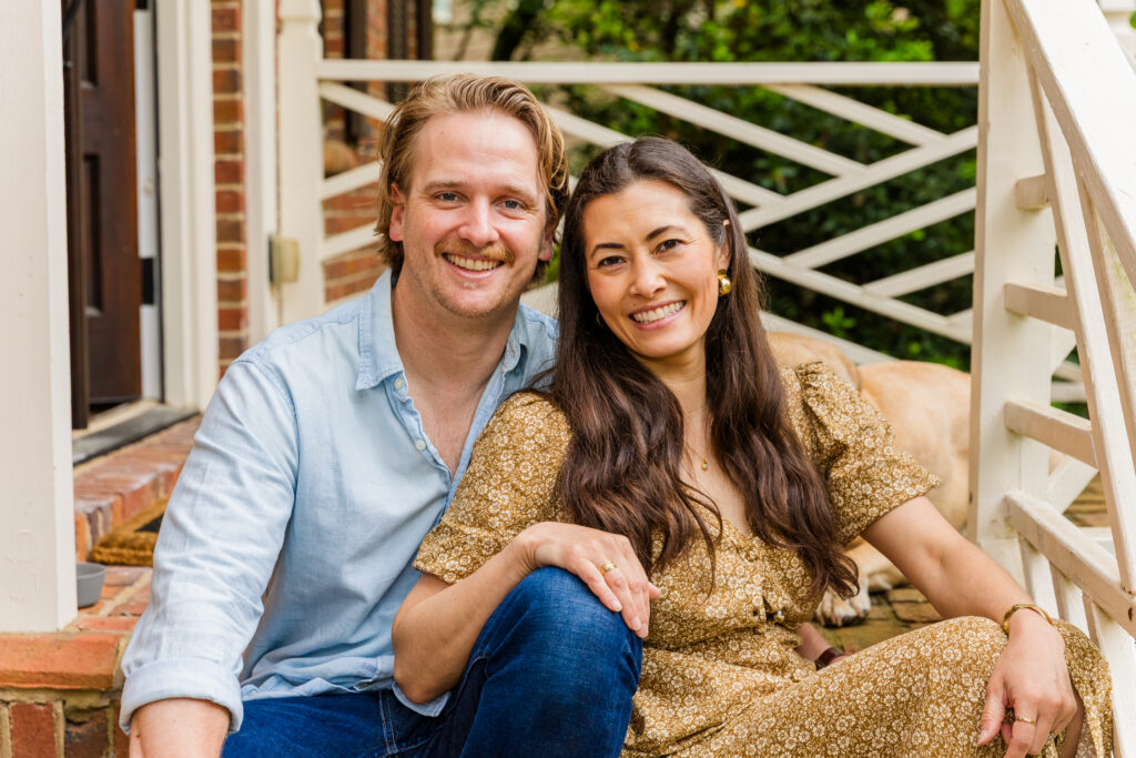 Parents sitting together on the front porch steps of their new Atlanta home.