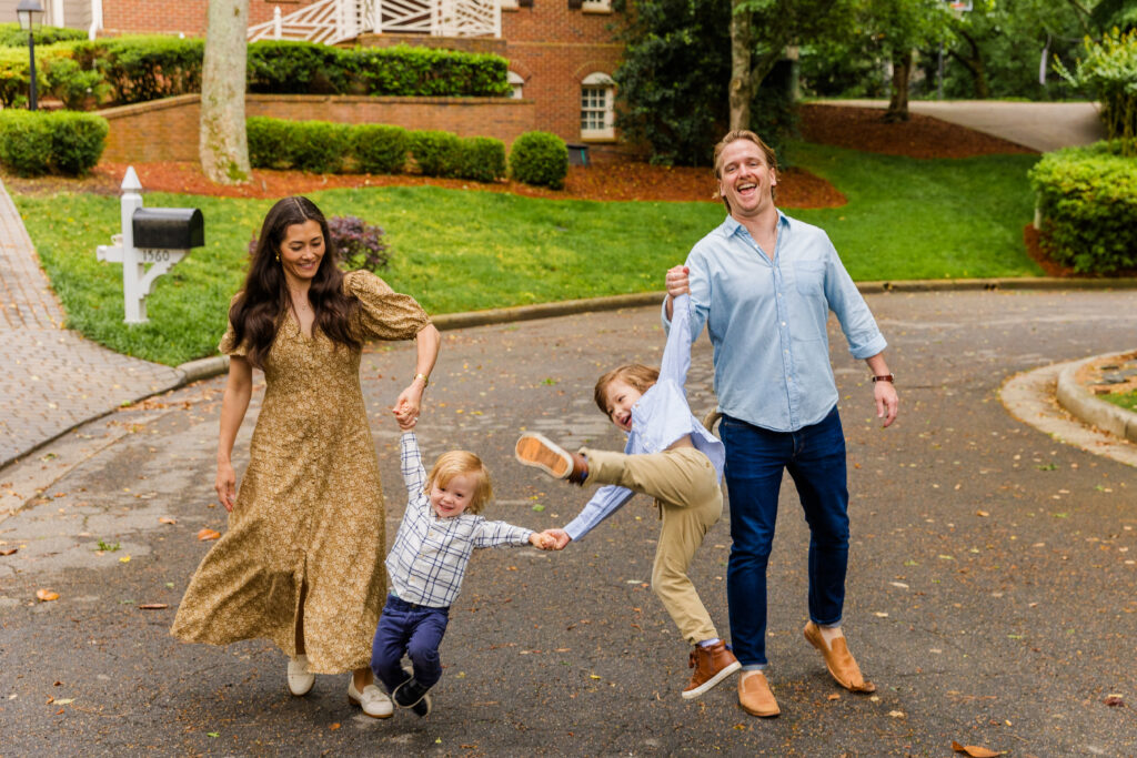 Family walking together swinging their sons joyfully through the air.