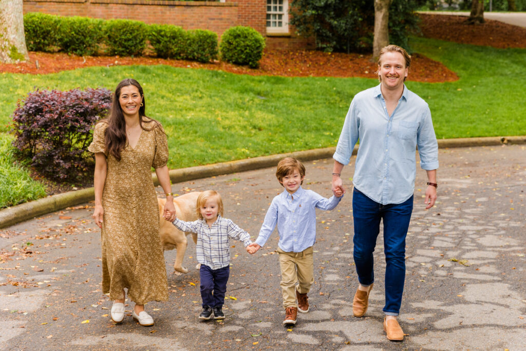 Family of four walking hand in hand through their Atlanta neighborhood.