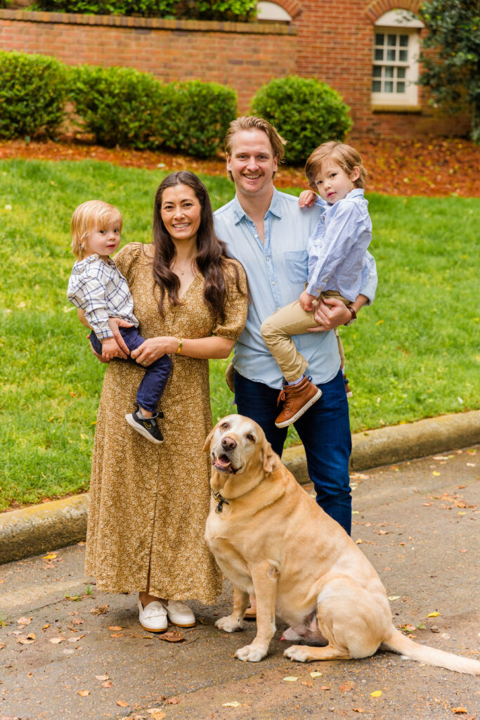 Classic family portrait with children in arms and dog sitting in front.