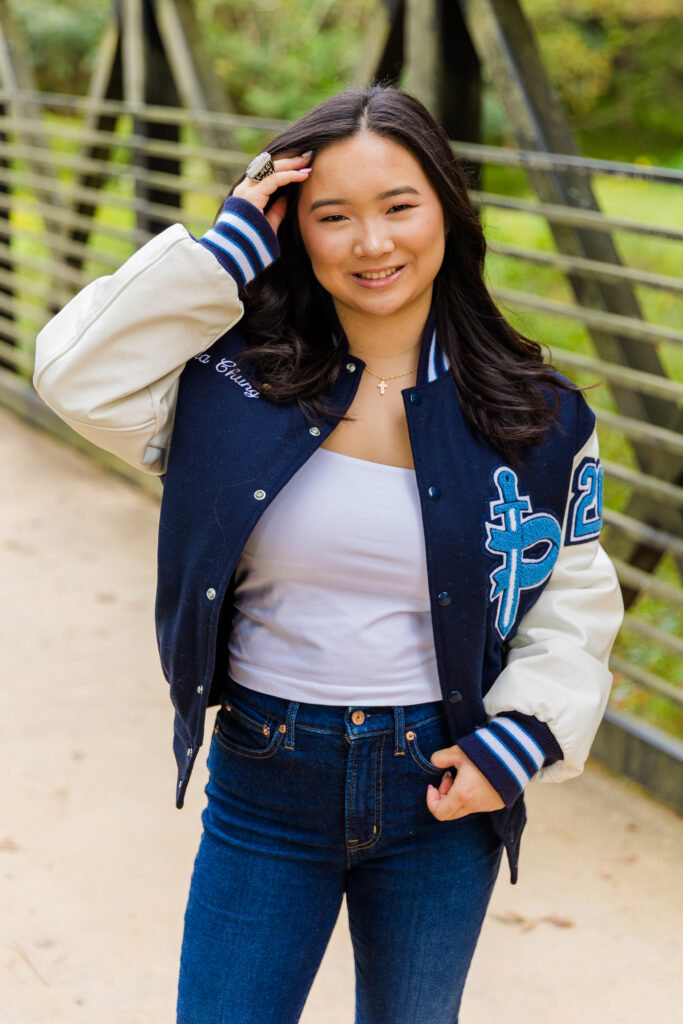 Pace Academy senior Mia posing on a park bridge, one hand in her pocket and the other in her hair.