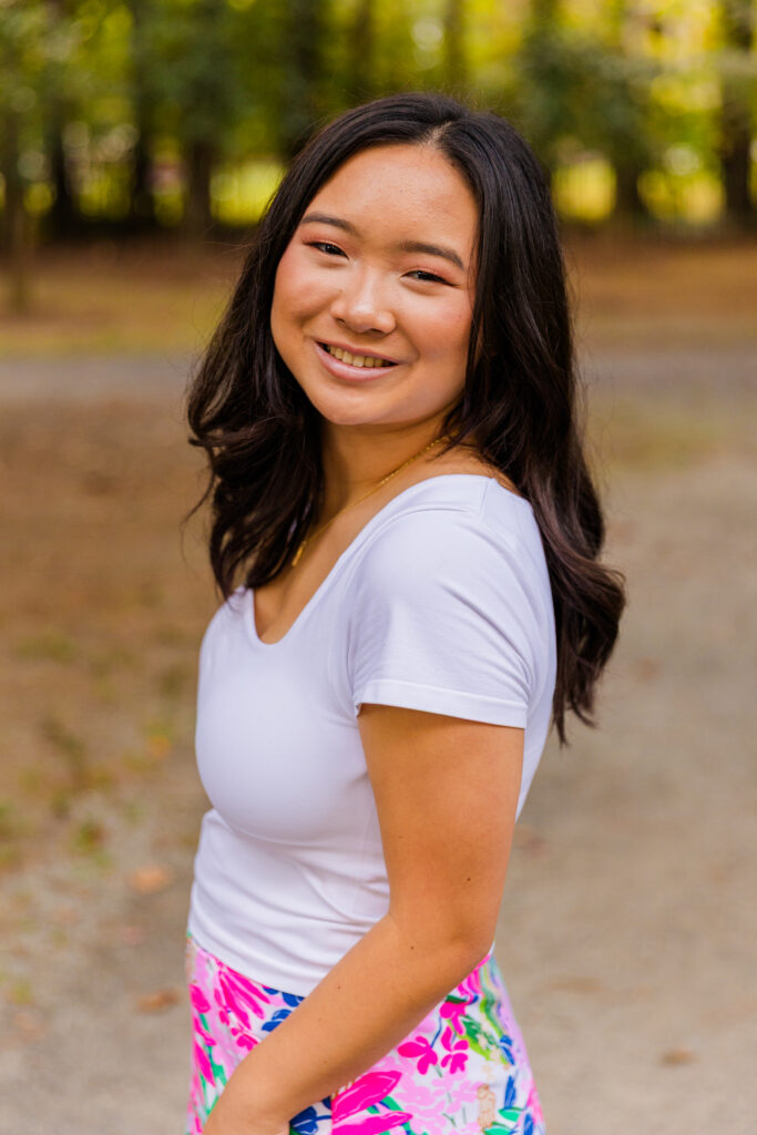 Close-up of Mia in white top and colorful skirt during her senior photos in Brookhaven park.