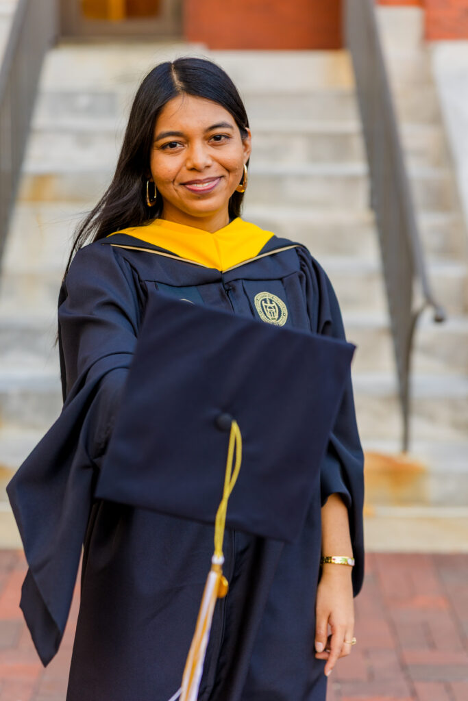 Pallovi showing her graduation cap blurred in the foreground during her Georgia Tech graduation session