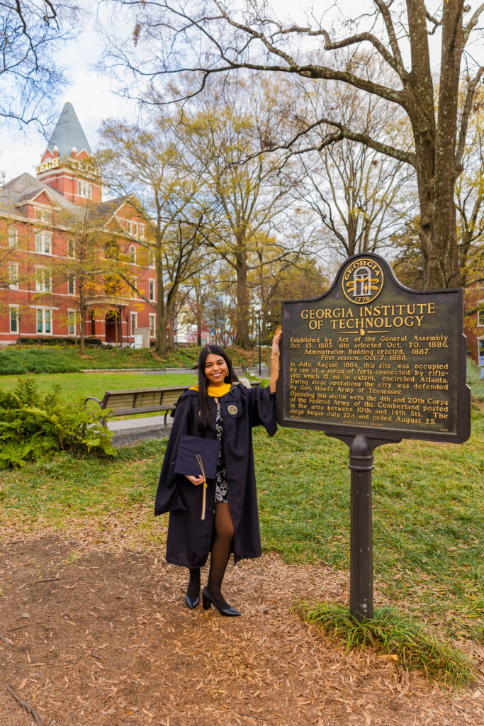 Wide shot of Pallovi next to the Georgia Tech sign with the GT Tower in the background during her graduation photos