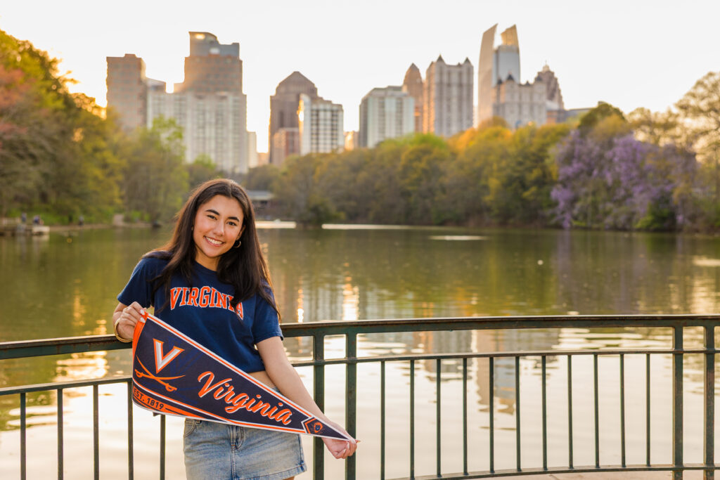 Atlanta senior photos by Laure Photography of senior holding UVA banner with Atlanta skyline
