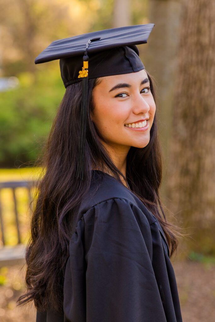 Close-up of Atlanta senior wearing graduation cap and gown looking over shoulder