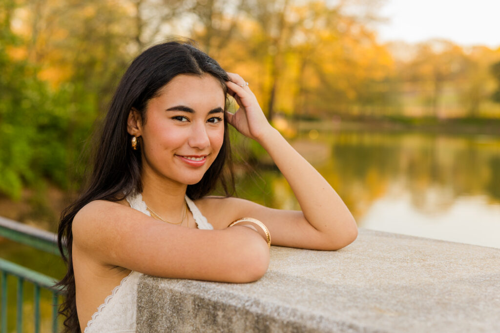 Centered portrait of senior leaning on bridge